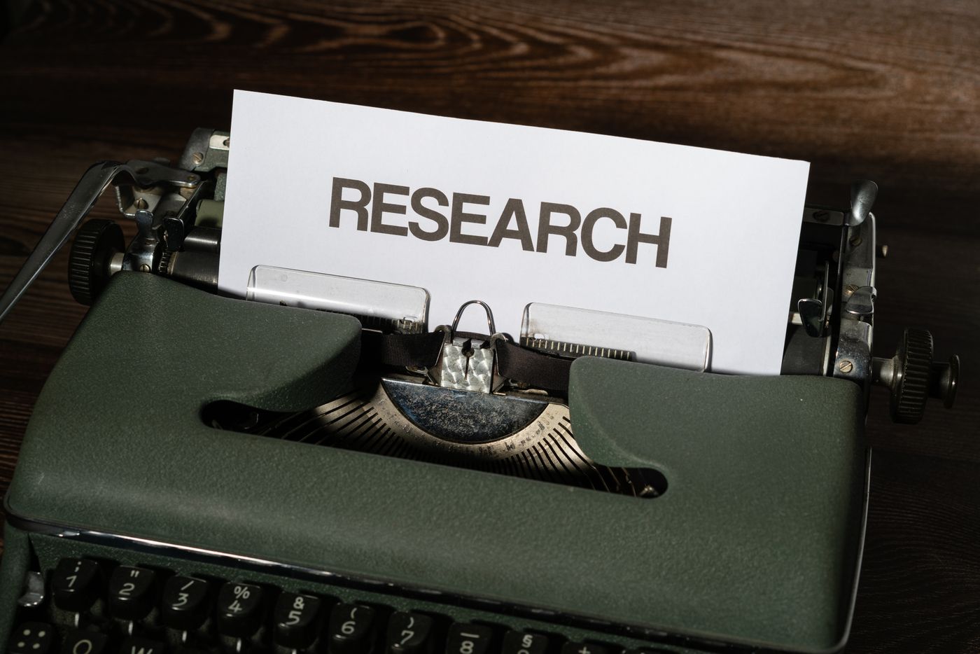 Vintage typewriter with a sheet reading RESEARCH, illustrating AI-written papers on arXiv and autonomous research agents