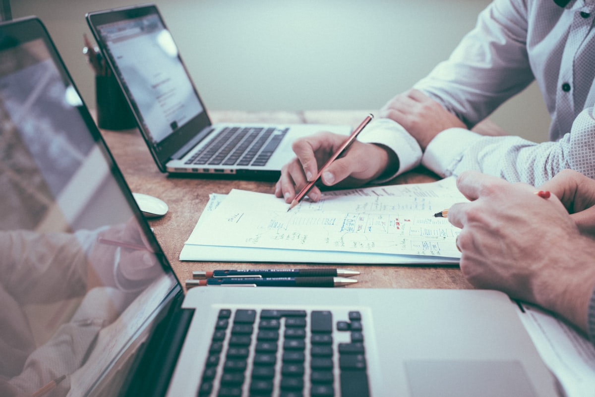 Person reviewing documents and spreadsheets at a professional desk representing the APEX-Agents benchmark workplace AI tasks