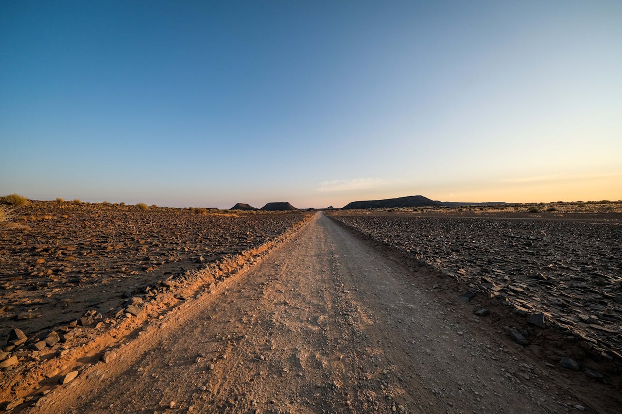 Long horizon desert road stretching into the distance representing AI agent autonomy over extended time horizons